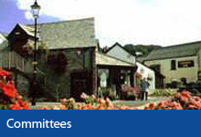 Committees button, Braunton Museum and Information Centre building with flowers in the foreground